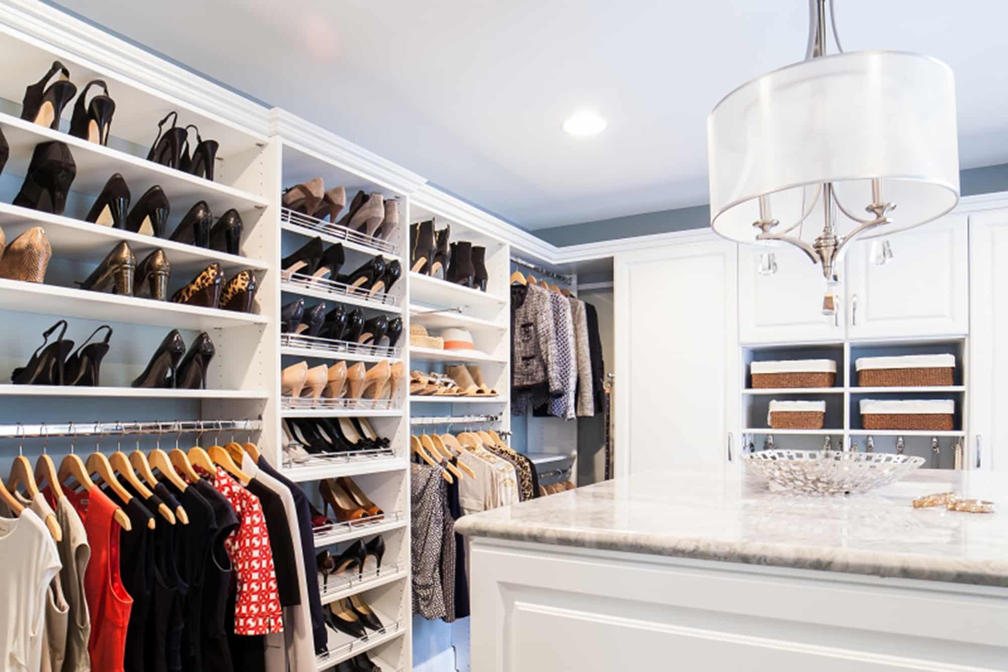 Large closet organizer system with white cabinetry for shoes and other clothing
