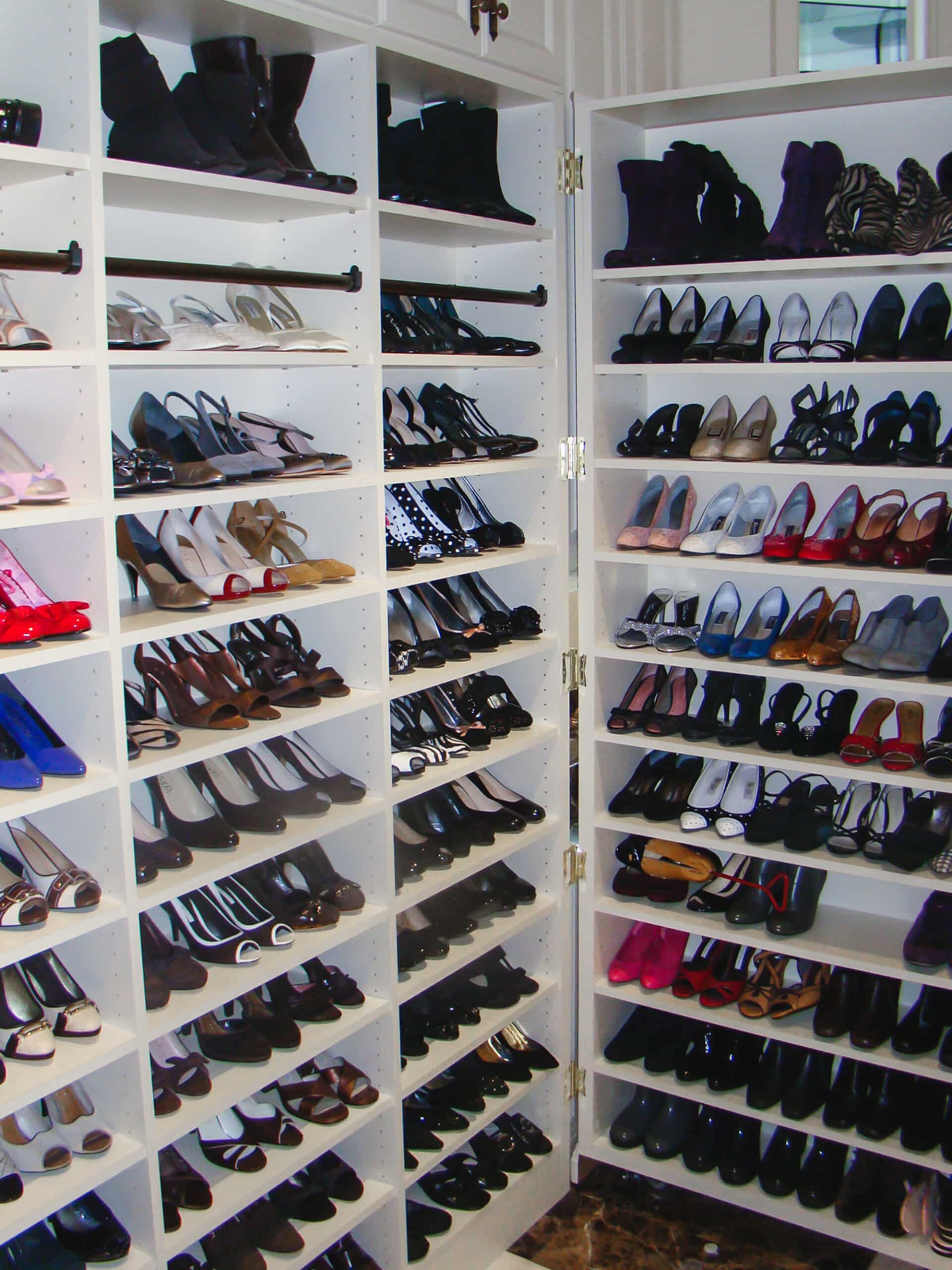 White shelving in a closet with a large shoe collection