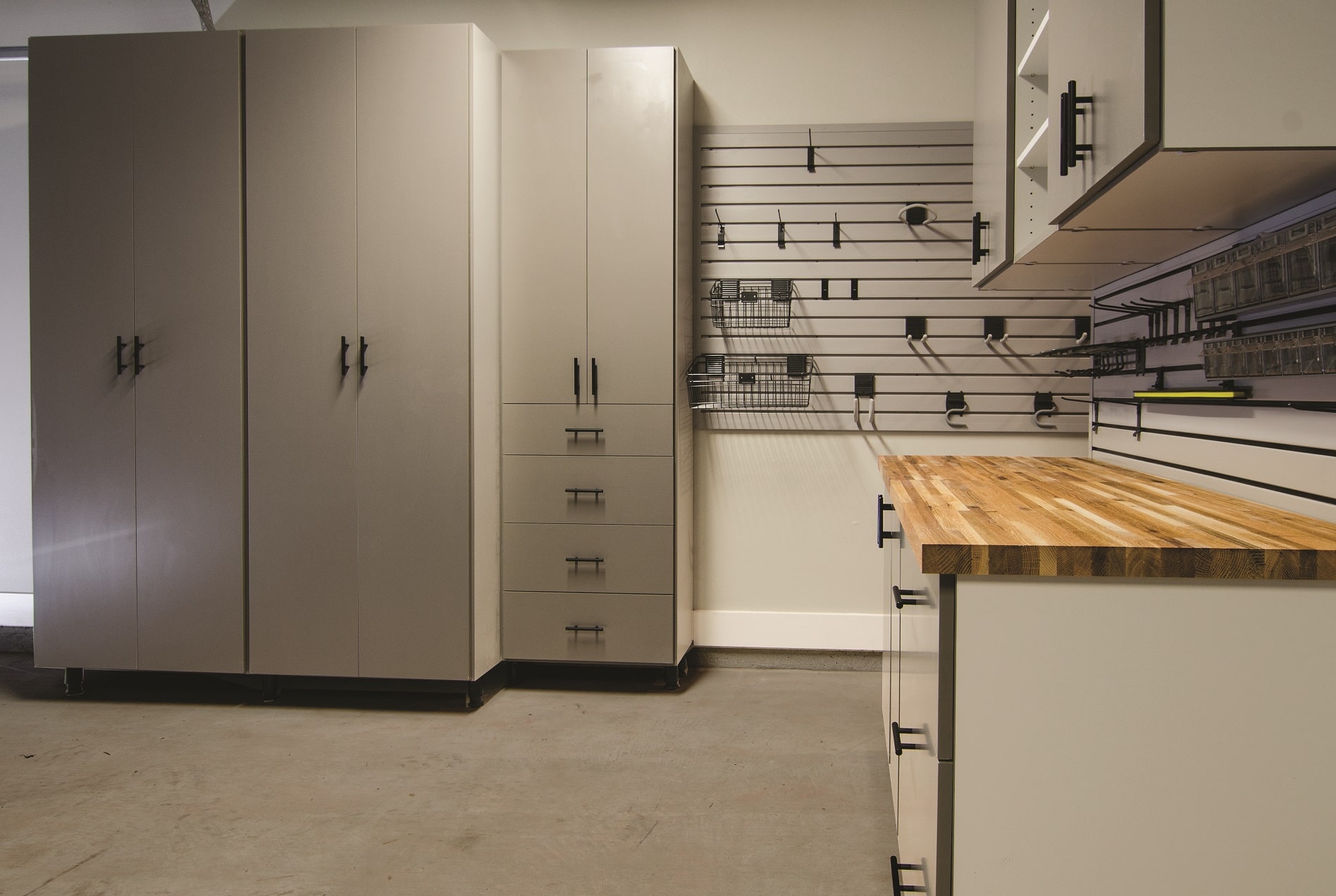 A clean, orderly garage with cabinetry and a workbench