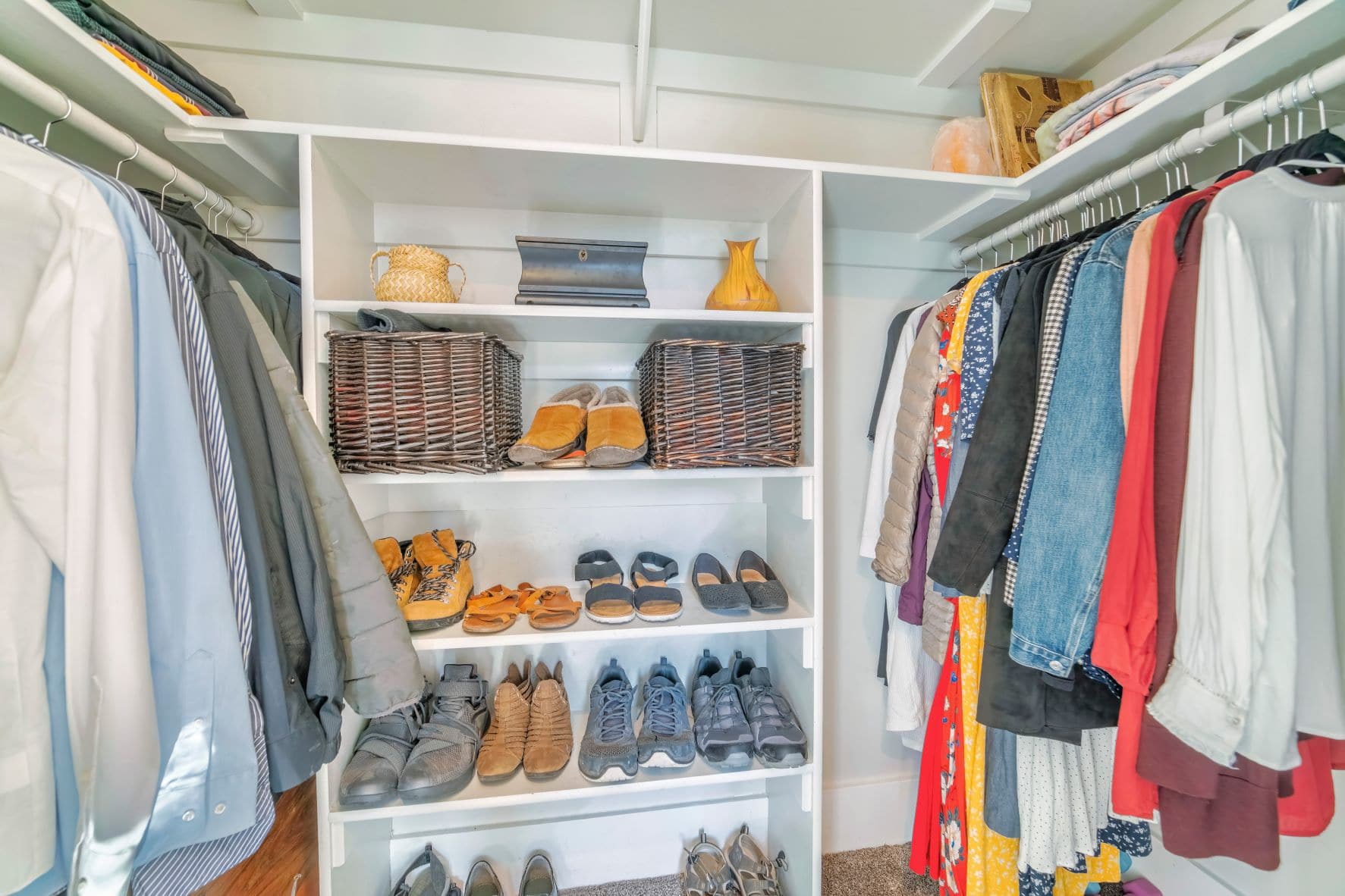 Custom closet with white shelving for shoes and hangers for clothing