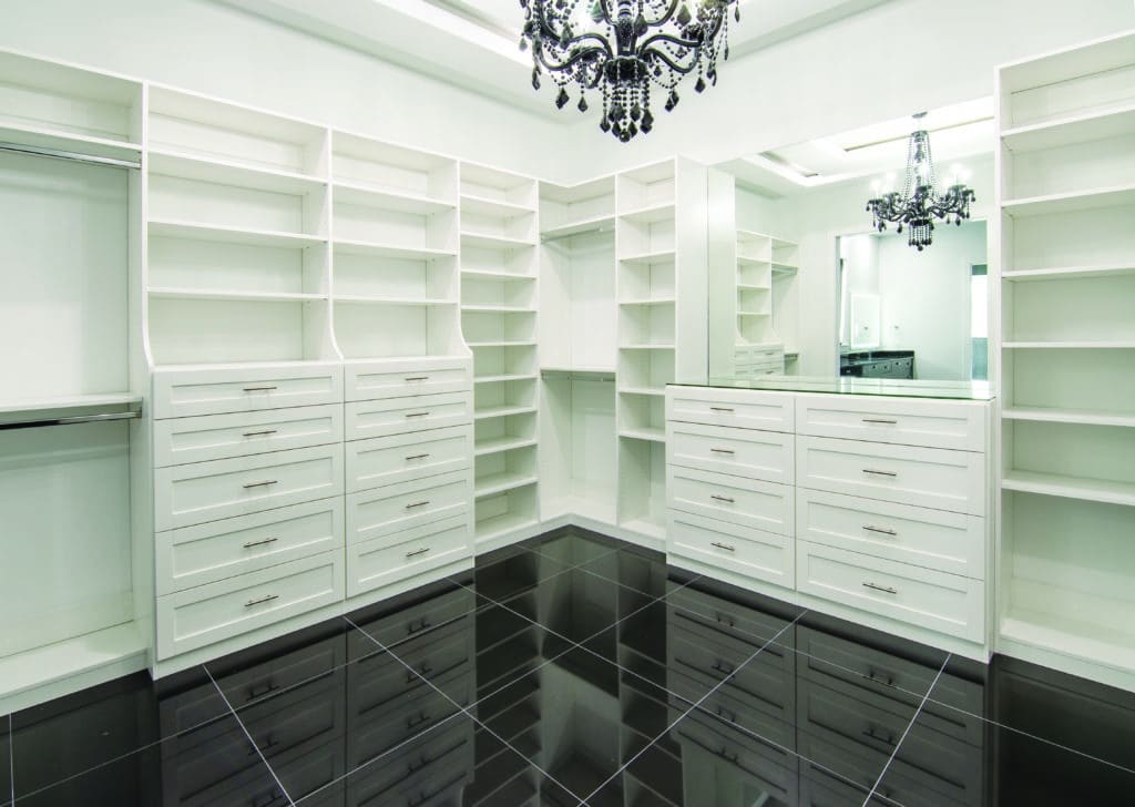 white cusom closet with dark floor and fancy lighting