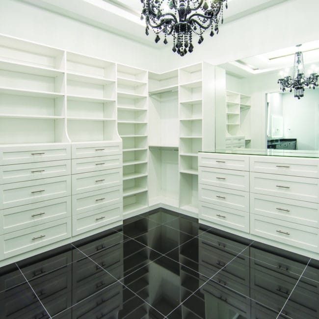 white cusom closet with dark floor and fancy lighting