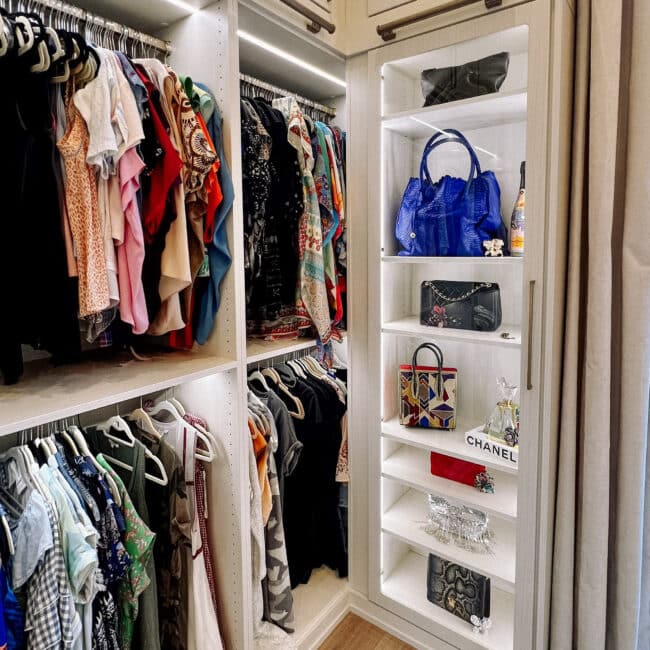 colorful purses and blouses stored in a bright white closet