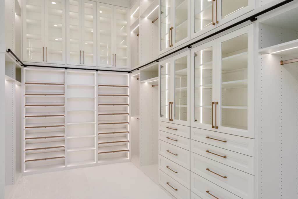 custom built closet with bright lighting and white shelves